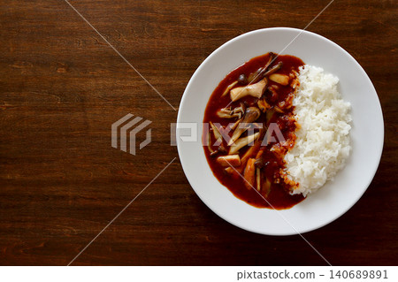 Mushroom curry rice with a table background viewed from directly above. Mushroom curry rice with a table background viewed from directly above. 140689891