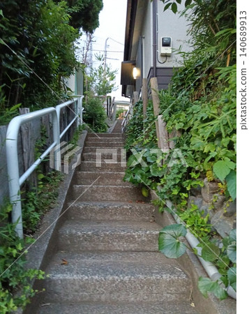 一條狹窄的樓梯通往住宅區和鬱鬱蔥蔥的綠地:它是日常生活、安全、本地資訊和城市基礎設施的重要組成部分。 一條狹窄的樓梯通往住宅區和鬱鬱蔥蔥的綠地:它是日常生活、安全、本地資訊和城市基礎設施的重要組成部分。 140689913