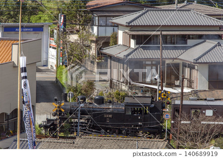 A C12 steam locomotive of the Mooka Railway passes outside a residential area. A C12 steam locomotive of the Mooka Railway passes outside a residential area. 140689919