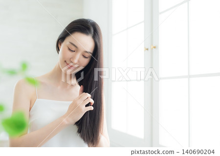 A woman touching her hair A woman touching her hair 140690204