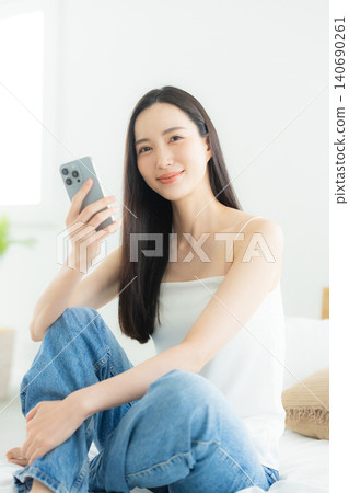 A woman watching a smartphone A woman watching a smartphone 140690261