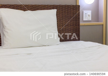 A clean bed and white pillows in the hotel room. 140690594