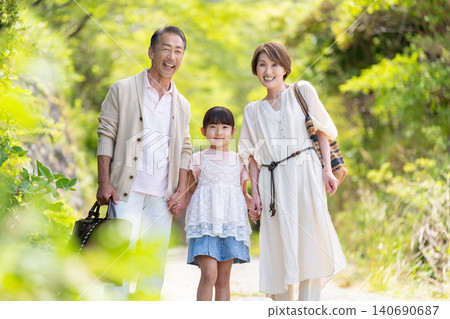 A three-generation family of a senior couple and their granddaughter enjoying a trip. A three-generation family of a senior couple and their granddaughter enjoying a trip. 140690687
