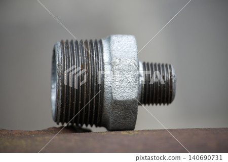 Close-up of metal pipe fitting showcasing detailed threads and texture 140690731
