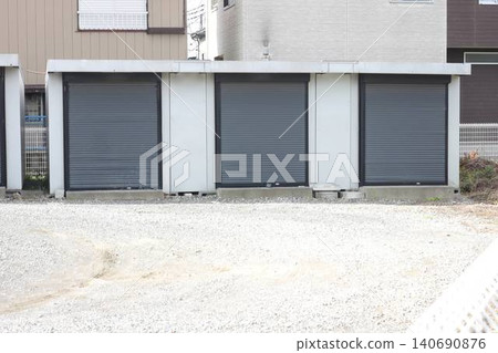Gray, shuttered container-type storage units lined up on the outdoor premises. 140690876