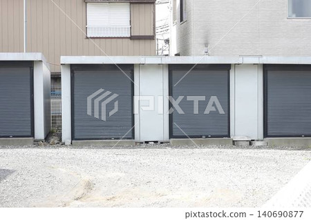 Gray, shuttered container-type storage units lined up on the outdoor premises. 140690877