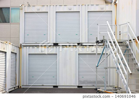 Exterior view of container-type storage units with stairs arranged in a multi-level layout as a land utilization project. Exterior view of container-type storage units with stairs arranged in a multi-level layout as a land utilization project. 140691046