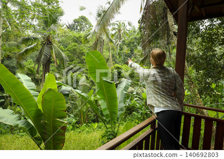 A person points towards the dense jungle in Bali A person points towards the dense jungle in Bali 140692803