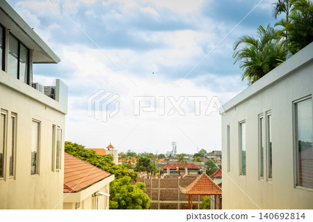 View from between buildings showing rooftops and clouds View from between buildings showing rooftops and clouds 140692814