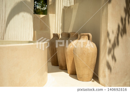 Terracotta pots rest alongside a charming bath in a peaceful setting Terracotta pots rest alongside a charming bath in a peaceful setting 140692816
