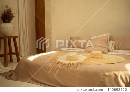Stylish bedroom featuring a neutral palette and decorative hats Stylish bedroom featuring a neutral palette and decorative hats 140692820