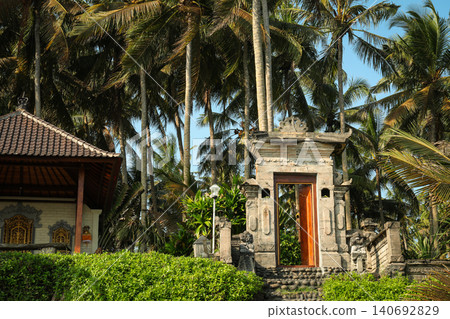 Visitors approach a temple entrance framed by palm trees Visitors approach a temple entrance framed by palm trees 140692829