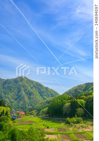 Contrails and rural scenery [Nagano Prefecture] 140694097