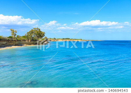 Idyllic south island coastline with clear turquoise waters and lush green vegetation 140694543