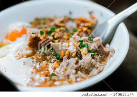A bowl of congee or porridge with boiled rice A bowl of congee or porridge with boiled rice 140695174