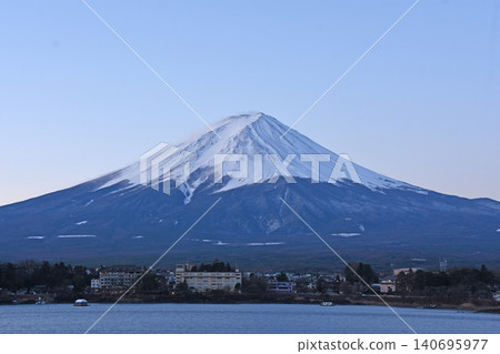 With the pale pink Venus Belt as a backdrop, the pure white winter peak of Mount Fuji stands majestically on the opposite shore of Lake Kawaguchi. With the pale pink Venus Belt as a backdrop, the pure white winter peak of Mount Fuji stands majestically on the opposite shore of Lake Kawaguchi. 140695977