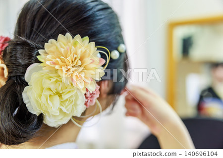 A woman in a kimono with a beautiful updo and a gorgeous floral hair ornament (viewed from behind). A woman in a kimono with a beautiful updo and a gorgeous floral hair ornament (viewed from behind). 140696104