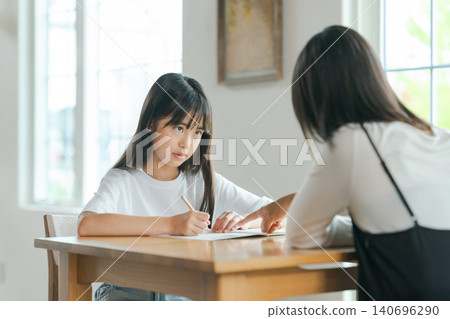 A mother teaching her child, and the child who doesn't want to. A mother teaching her child, and the child who doesn't want to. 140696290
