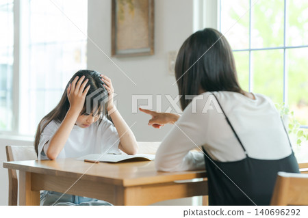 一位母親在教導她的孩子,但孩子卻不想學。 一位母親在教導她的孩子,但孩子卻不想學。 140696292