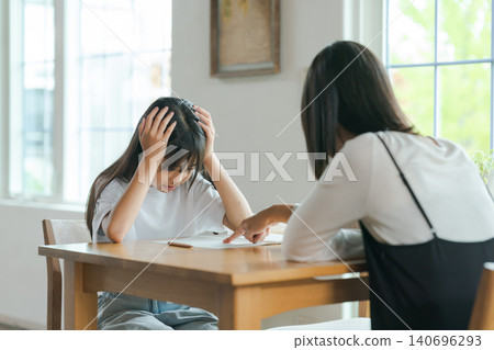 一位母親在教導她的孩子,但孩子卻不想學。 一位母親在教導她的孩子,但孩子卻不想學。 140696293