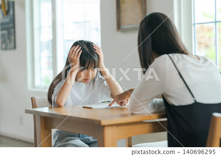 一位母親在教導她的孩子,但孩子卻不想學。 一位母親在教導她的孩子,但孩子卻不想學。 140696295