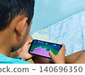 portrait of a child playing games on a smartphone 140696350