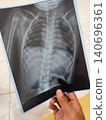 A patient is looking at an X-ray of internal organs. 140696361