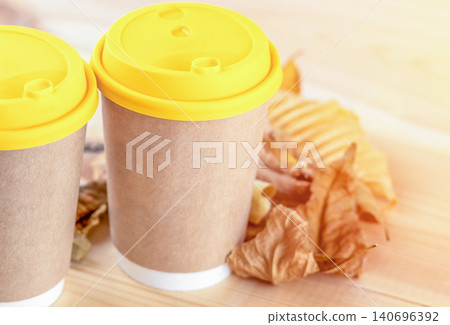 Disposable coffee cups with paper sleeves on a wooden table Disposable coffee cups with paper sleeves on a wooden table 140696392