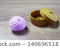 Anti-stress toy in the shape of a pink dumpling squishy lying near the box 140696518