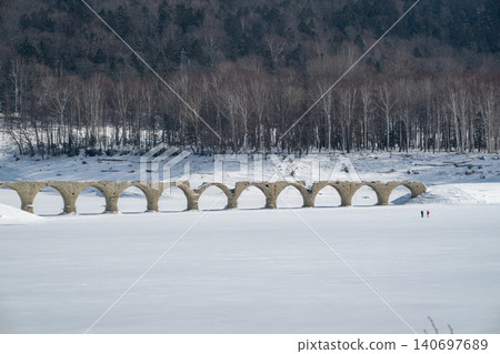 The Taushubetsu River Bridge stands in a snow-covered field during winter. The Taushubetsu River Bridge stands in a snow-covered field during winter. 140697689