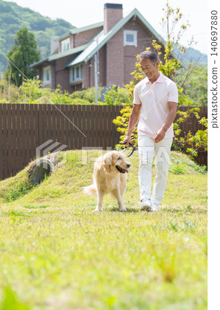 A senior man enjoys walking his dog in his garden. A senior man enjoys walking his dog in his garden. 140697880
