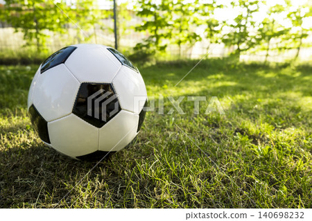 Classic black and white soccer ball a vibrant green grass, representing an iconic symbol of global football culture. 140698232