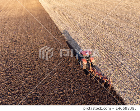 Aerial view of tractor plowing a field. Agricultural machinery, agrimotor, working in the field on sunrise 140698383