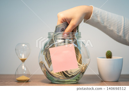 Taking saved up money from jar, blank paper for inscription. Using money saved up for a long time Taking saved up money from jar, blank paper for inscription. Using money saved up for a long time 140698512