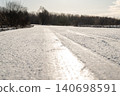 Slippery frozen road on gloomy winter day, close up. Fast change of weather, icy road, tire tracks 140698591