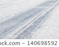 Tire tracks on an icy frozen road, close up. Winter season, slippery road, dangerous for driving 140698592