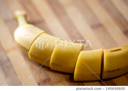 Sliced banana on the wooden table, close up. Healthy food, vitamins, tropical fruit, breakfast concept Sliced banana on the wooden table, close up. Healthy food, vitamins, tropical fruit, breakfast concept 140698600