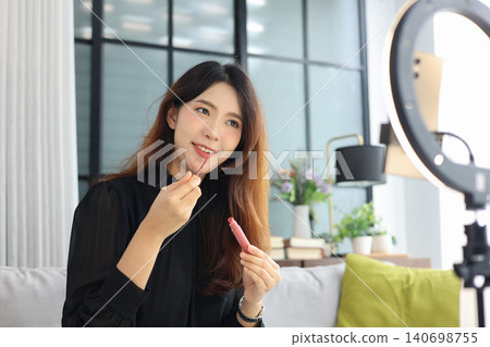 Young Asian influencer filming a beauty makeup tutorial video at home. Young Asian influencer filming a beauty makeup tutorial video at home. 140698755
