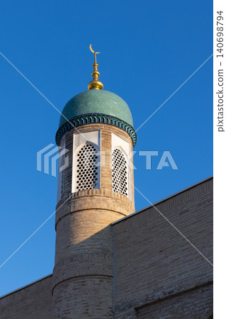 Sunlit mosque minaret topped with a turquoise dome and golden crescent finial Sunlit mosque minaret topped with a turquoise dome and golden crescent finial 140698794