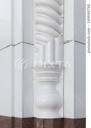 Close-up of a white ornate architectural column showing classical decorative carving Close-up of a white ornate architectural column showing classical decorative carving 140698798