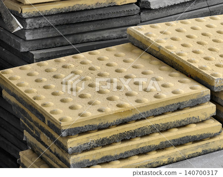 Stack of yellow tactile paving blocks for visually impaired pedestrians. 140700317
