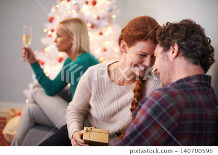 Christmas, gift and couple embrace with love for holiday in home, smile and happiness. Marriage, woman and man as husband and wife in house for celebration of festive, season and romance on vacation Christmas, gift and couple embrace with love for holiday in home, smile and happiness. Marriage, woman and man as husband and wife in house for celebration of festive, season and romance on vacation 140700596