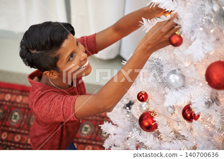 Woman, Christmas tree and hanging ornament for decoration in home, smile and festive season. Female person, religious holiday and prepare for celebration in living room, happiness and tradition 140700636