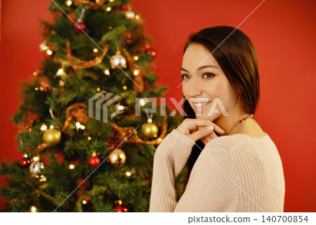 Happy woman, portrait and thinking by christmas tree on red background and gratitude for winter holiday. Young lady, planning and smile for xmas season of giving, indoor and creative idea for gifts Happy woman, portrait and thinking by christmas tree on red background and gratitude for winter holiday. Young lady, planning and smile for xmas season of giving, indoor and creative idea for gifts 140700854