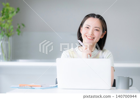 A housewife considers NISA (Nippon Individual Savings Account) for wealth building, focusing on stocks and investment trusts; she smiles at the camera while discussing measures to address rising inflation for household finances and the future. A housewife considers NISA (Nippon Individual Savings Account) for wealth building, focusing on stocks and investment trusts; she smiles at the camera while discussing measures to address rising inflation for household finances and the future. 140700944