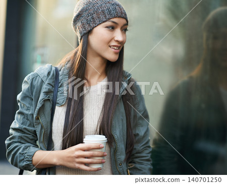 Woman, fashion and window with city, coffee and urban street or background for style. Female student, beanie and jacket in cape town with winter, cold and travel with morning commute for confidence 140701250