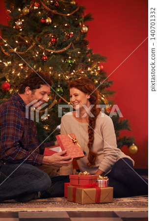 Couple, tree for Christmas and gift for holiday celebration, festive season of giving for love and commitment. Happy, gratitude and support with people at home for present, romance and relationship Couple, tree for Christmas and gift for holiday celebration, festive season of giving for love and commitment. Happy, gratitude and support with people at home for present, romance and relationship 140701332