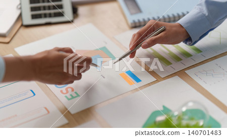 Business partners analyzing ESG reports and charts on desk for sustainable investment strategy Business partners analyzing ESG reports and charts on desk for sustainable investment strategy 140701483