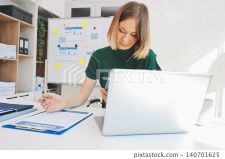 Happy female entrepreneur using smart phone in office. Happy female entrepreneur using smart phone in office. 140701625