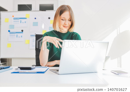 Concept of business working, Businesswoman sitting while writing and checking business analytic document report and holding tablet with computer pc, smartphone on desk in her workstation. Concept of business working, Businesswoman sitting while writing and checking business analytic document report and holding tablet with computer pc, smartphone on desk in her workstation. 140701627